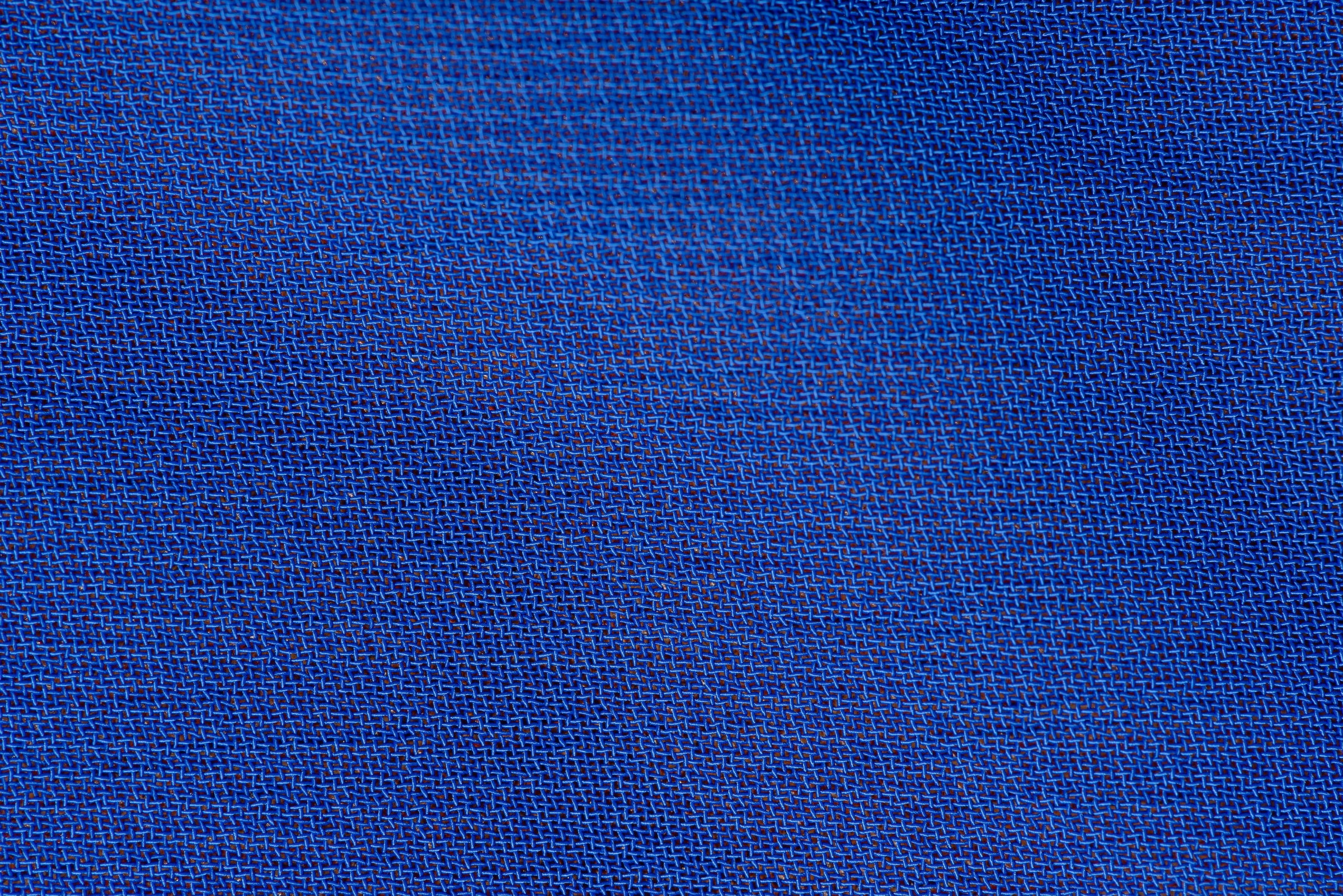 Macro close-up of royal blue woven performance fabric showing a fine textured weave