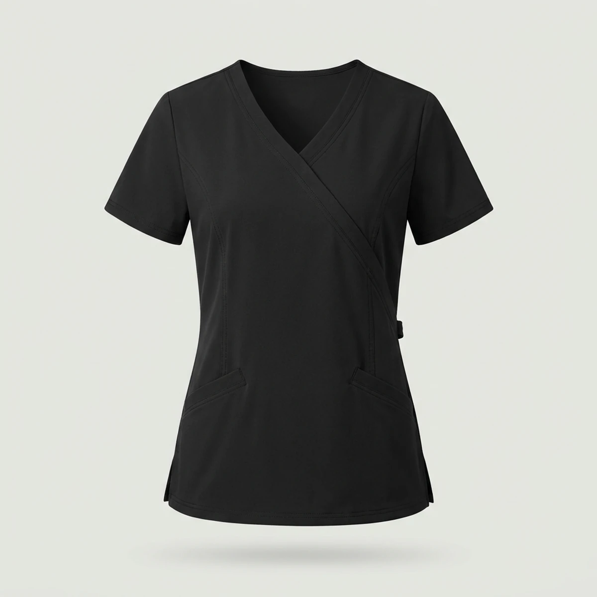 Black mock wrap scrub top with side tie detail and angled welt pockets